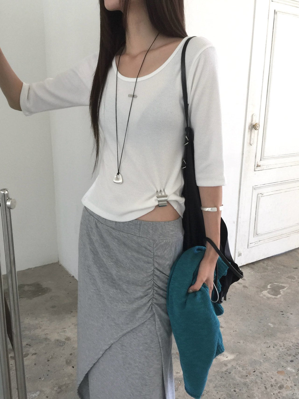 Nweol waffle knit crop top in Charcoal, flat lay on black bench sleeve detail close-up