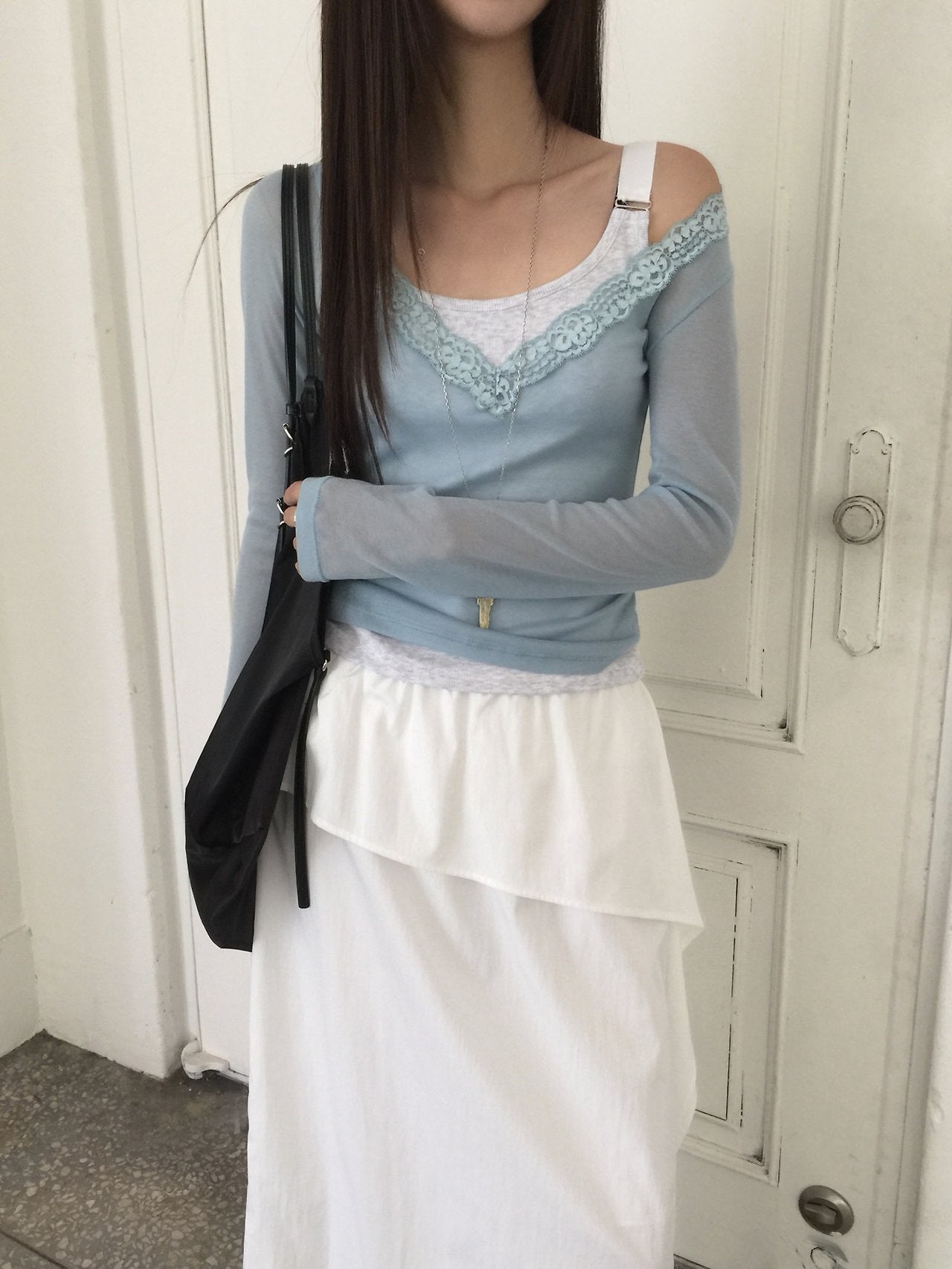 Nweol lace trim V-neck long sleeve top in Soft Blue, styled on model seated front view close-up lace detail
