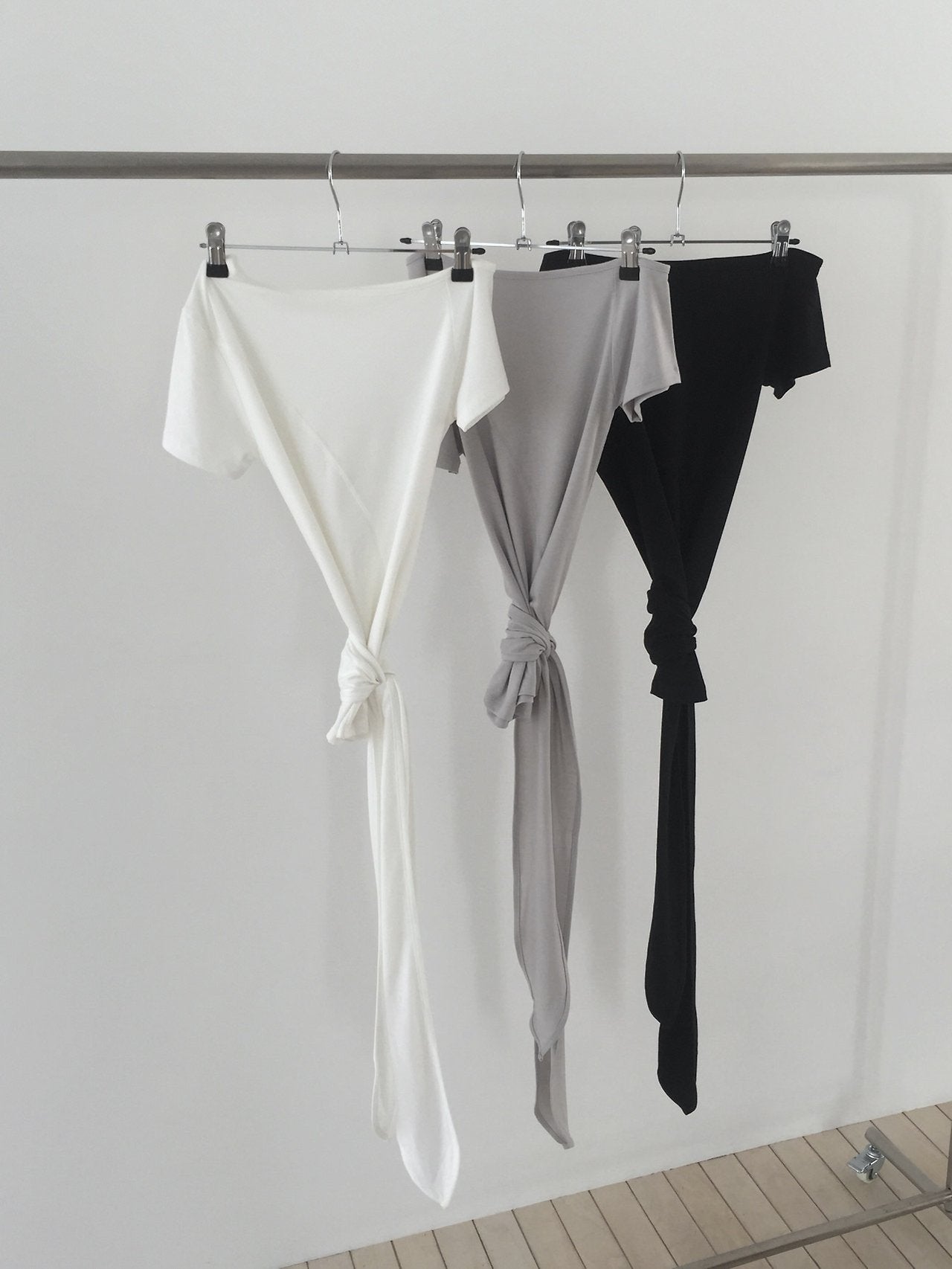 Nweol off-shoulder crop top with tie waist in Ivory, Light Grey and Black, three colorways on rack back view