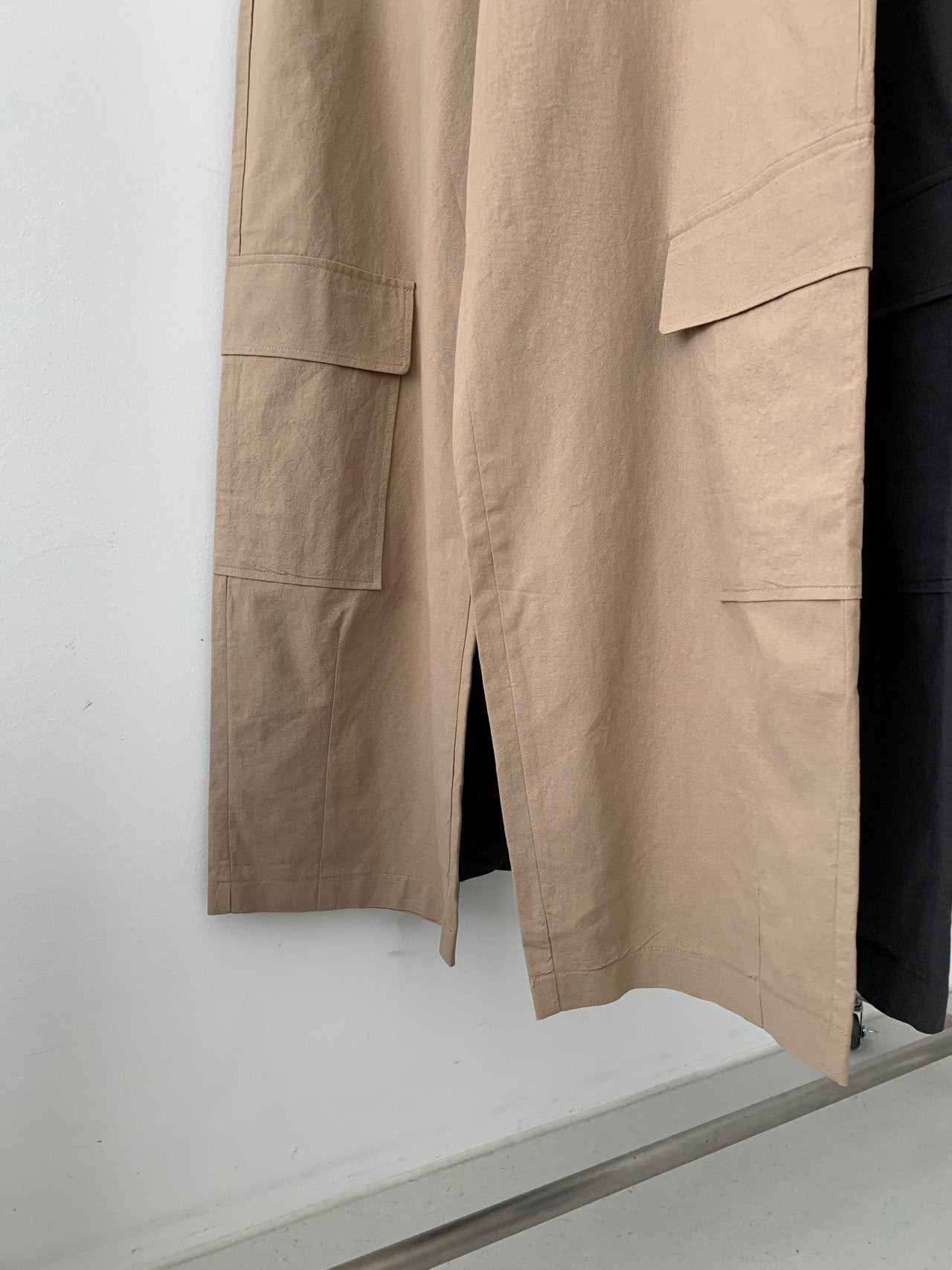 Vivel multi cargo pocket wide leg pants in Charcoal and Dark Beige, two colorways product flat lay on white surface