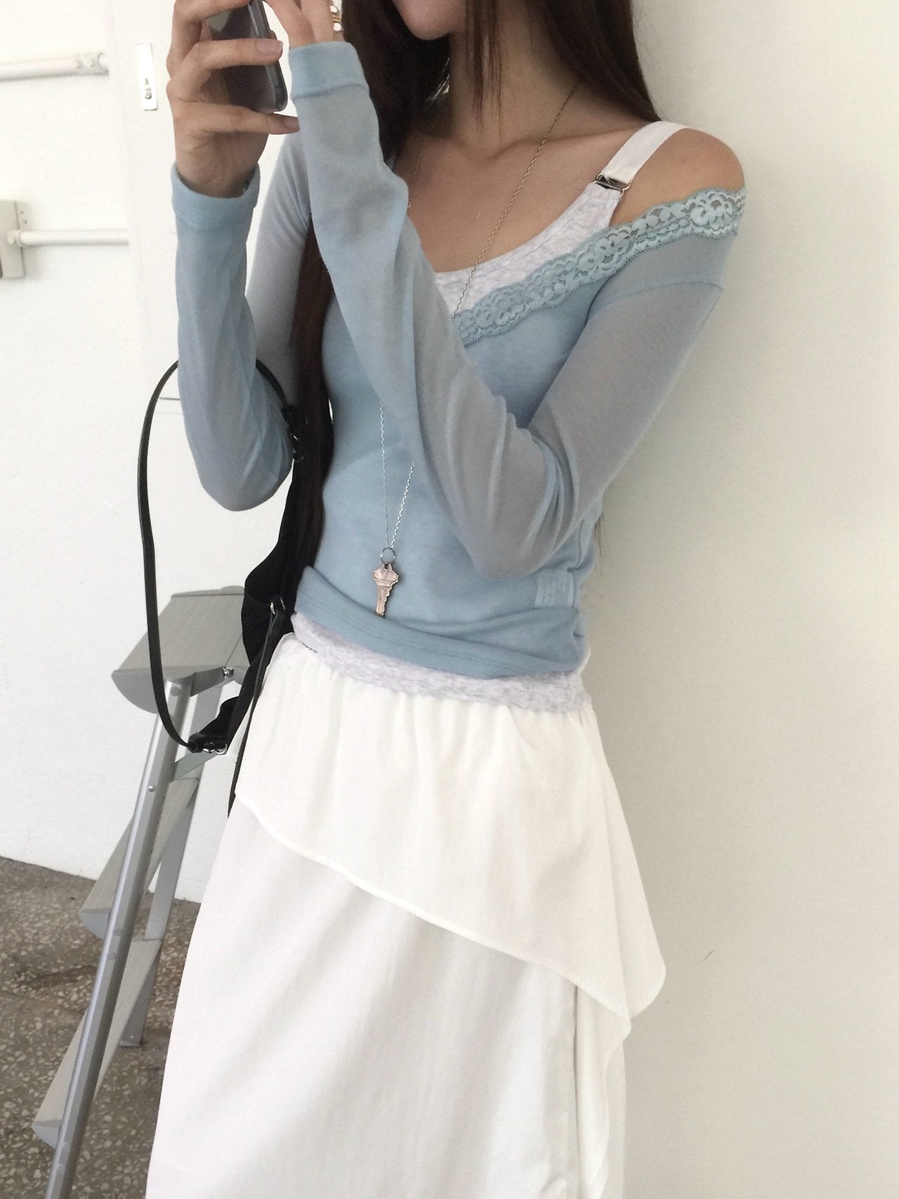 Nweol lace trim V-neck long sleeve top in Soft Blue, styled on model seated side view