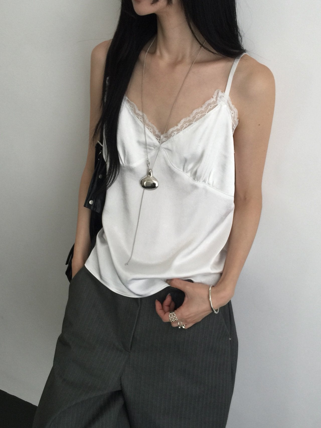 Nweol lace trim satin tank top in Ivory, styled on model front view with grey wide leg trousers standing