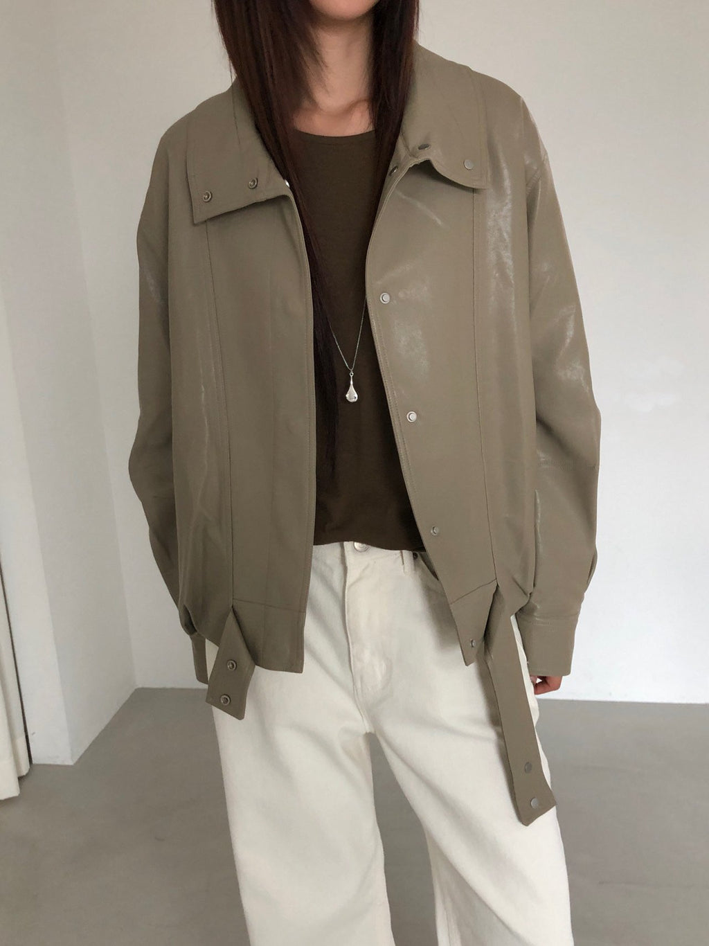 Side view of beige jacket with long sleeves and snap cuffs