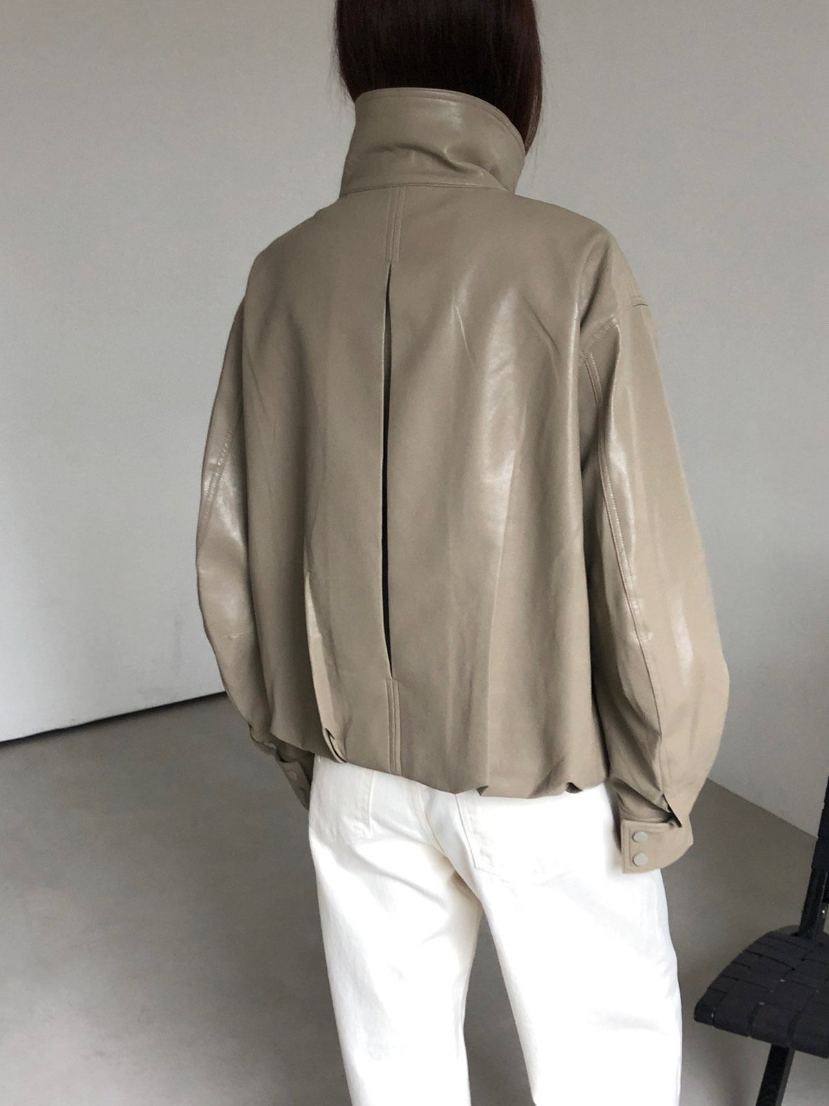 Open front of beige snap-button jacket with hanging hem tabs