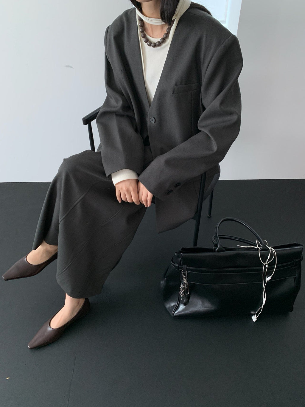 Charcoal collarless jacket seated styling