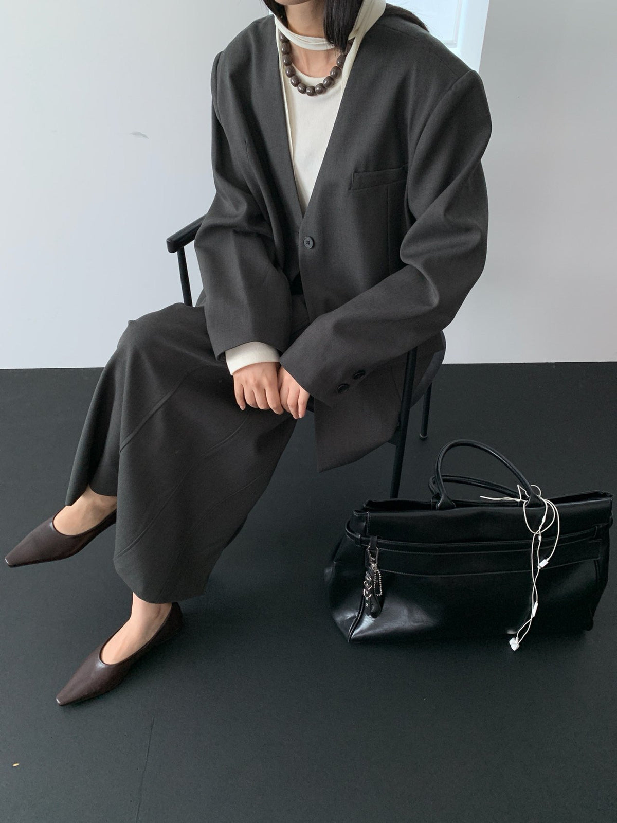 Charcoal collarless jacket seated styling