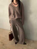 Side view of charcoal wide-leg knit pants worn with a grey top