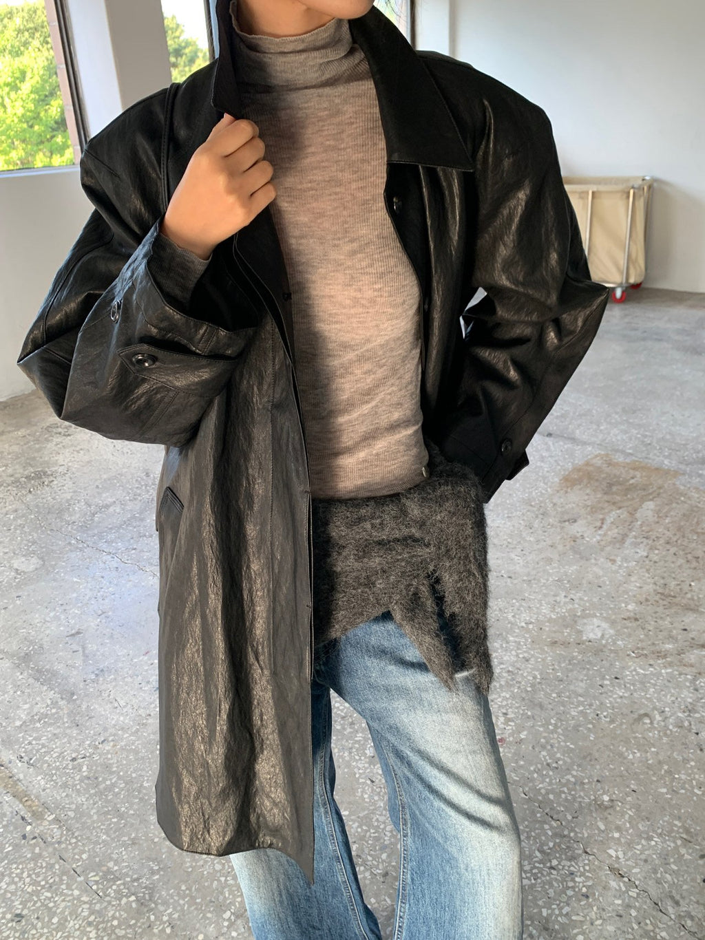 Ivory, grey, brown and black turtleneck sweaters displayed on hangers