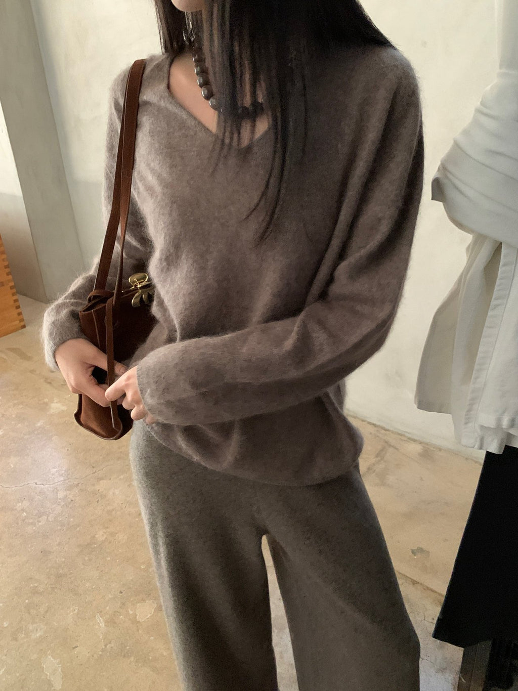 Ivory long-sleeve sweater worn while seated on steps