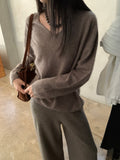Ivory long-sleeve sweater worn while seated on steps