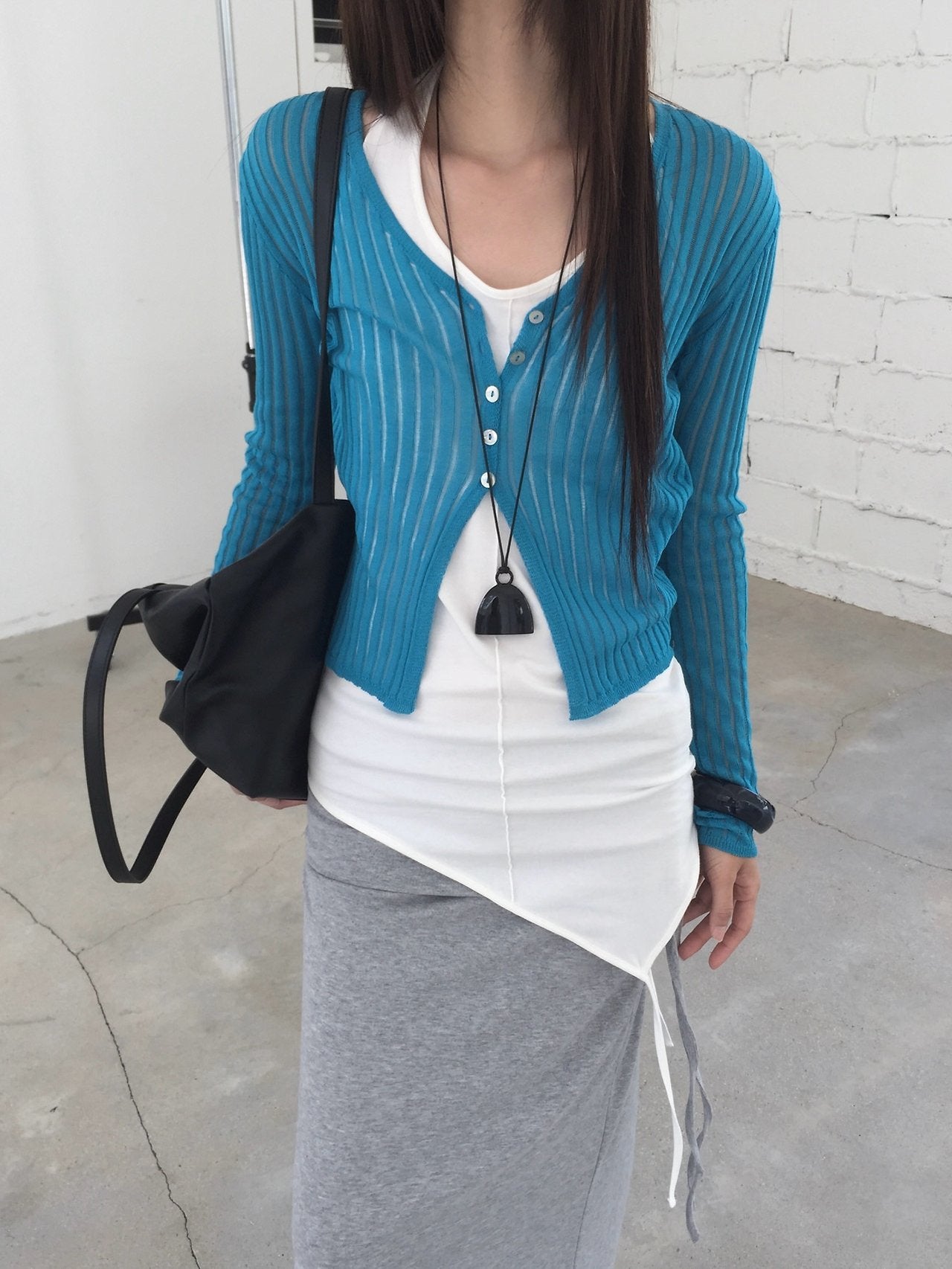 Nweol ribbed open knit crop cardigan in Brown, styled on model front view with grey tank top and white wide leg pants