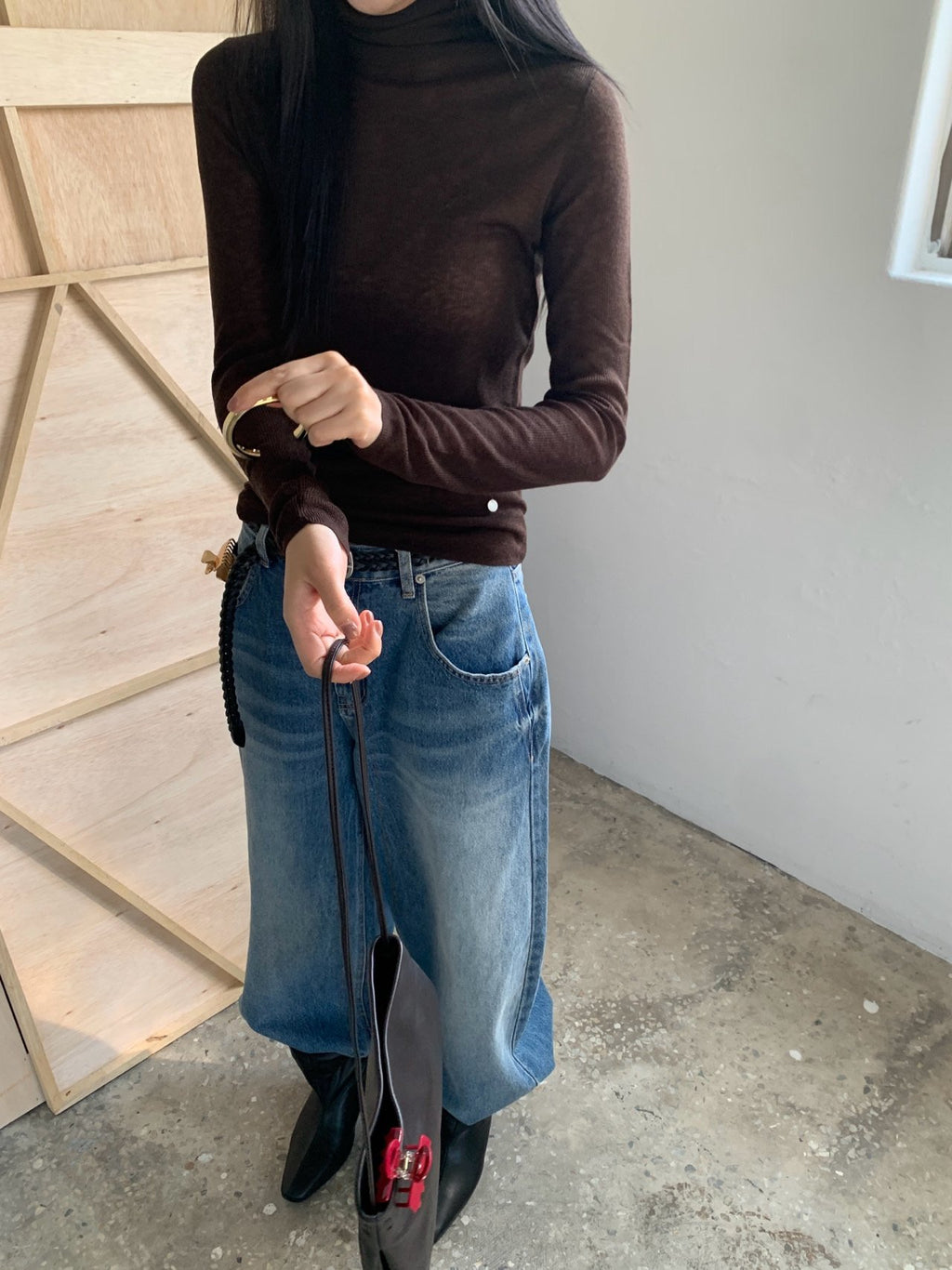 Brown long-sleeve turtleneck sweater styled with a denim skirt