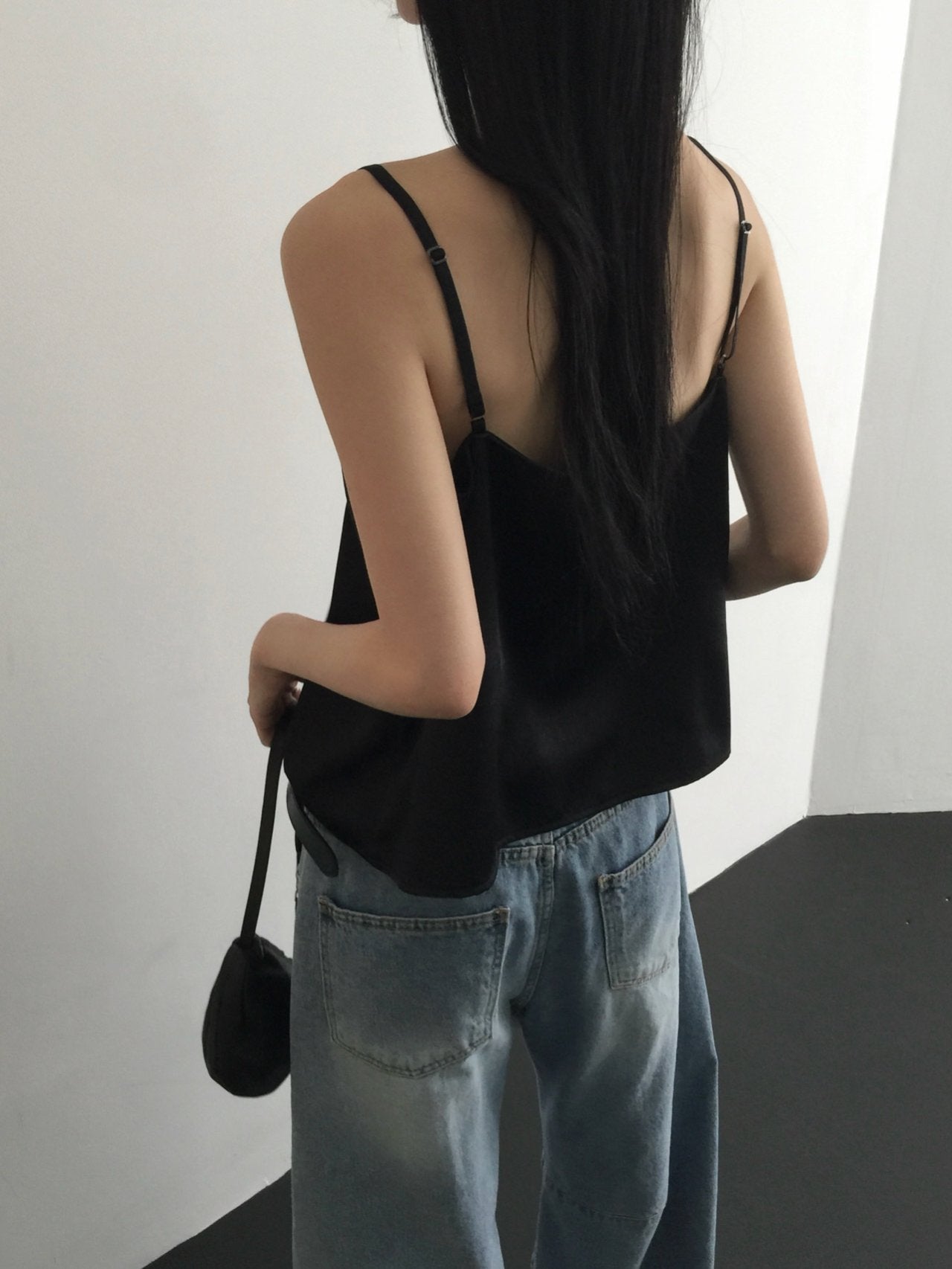Nweol lace trim satin tank top in Black, styled on model front view with light blue wide leg jeans