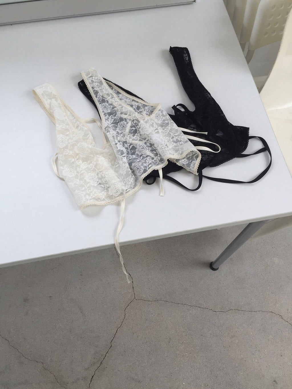 Nweol floral lace sheer bustier in Cream and Black, two colorways product flat lay on white table
