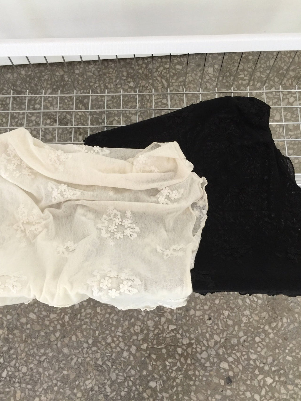Nweol one-shoulder floral lace mesh top in Cream Ivory, styled on model front view with black wide leg pants