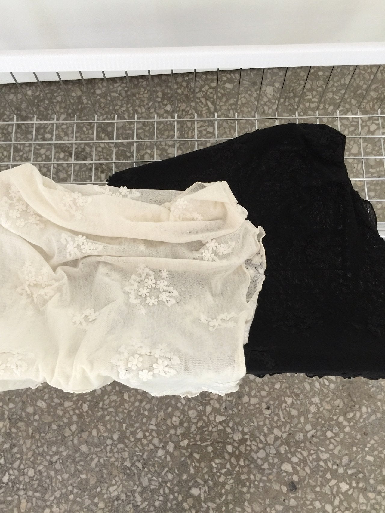 Nweol one-shoulder floral lace mesh top in Cream Ivory, styled on model front view with black wide leg pants