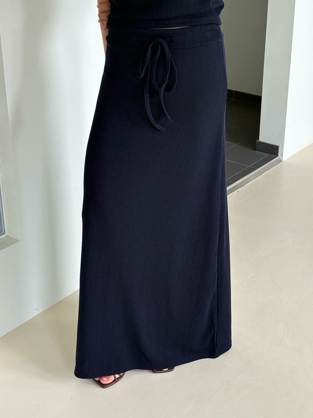 Back view of brown short-sleeve top and pleated maxi skirt set