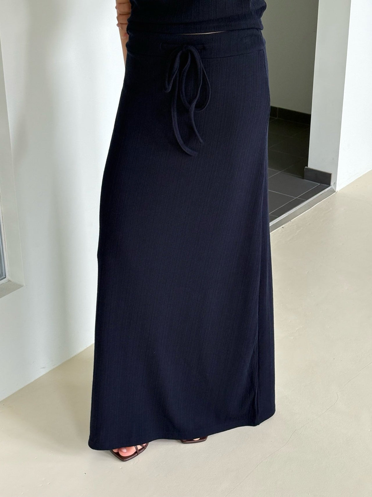 Back view of brown short-sleeve top and pleated maxi skirt set