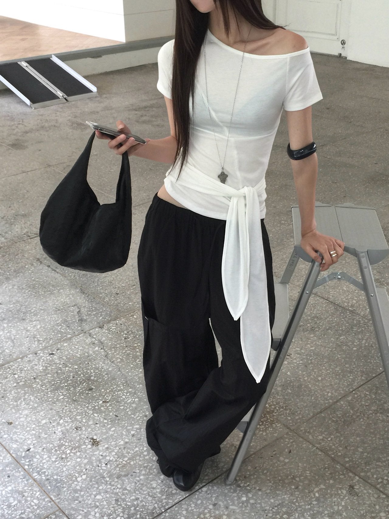 Nweol off-shoulder crop top with tie waist in Light Grey, styled on model seated front view tie waist detail