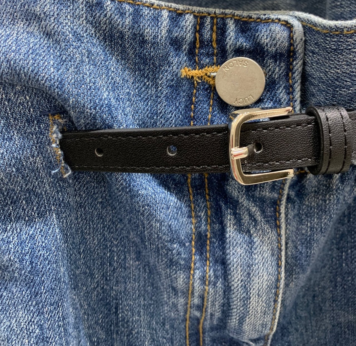 Side and back view of blue jeans showing back pocket and belt