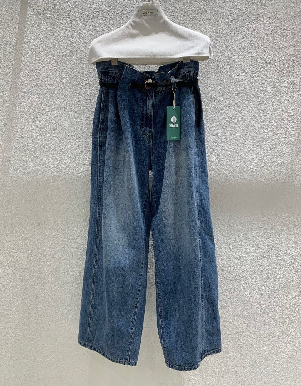 Front view of blue wide-leg jeans with included black belt