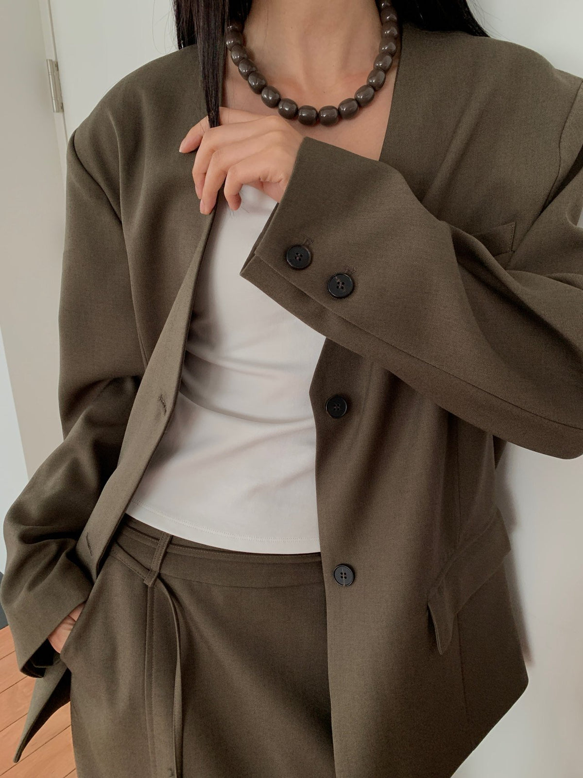 Close-up of Lucysalon Khaki Brown jacket button and sleeve detail