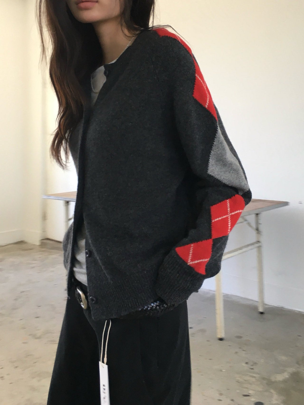 Side view of charcoal cardigan with red and gray argyle sleeve