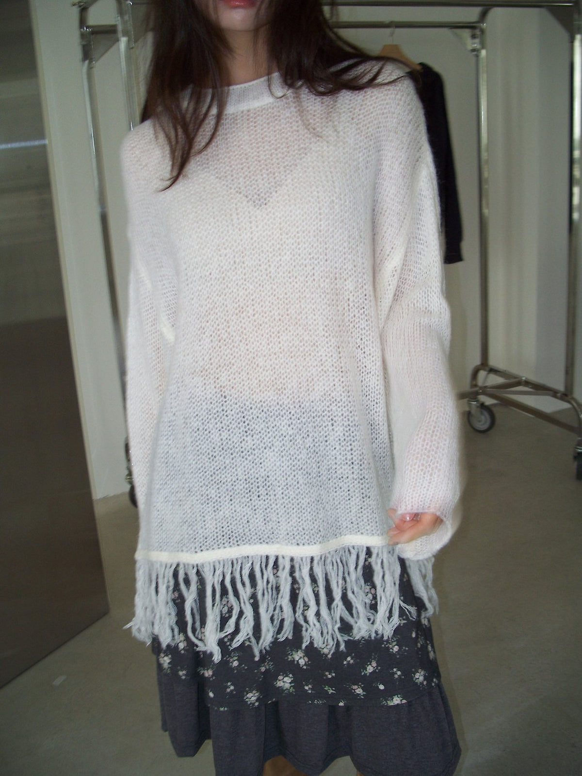 Open-Knit Fringe Sweater Ivory and Charcoal hanging on rack front view