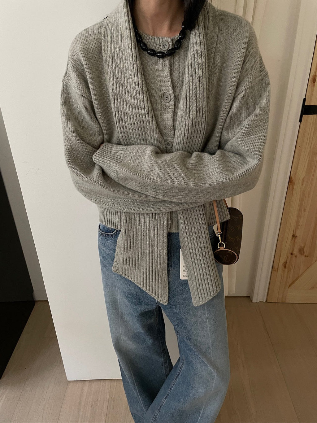 Charcoal cardigan and matching scarf worn over an ivory dress