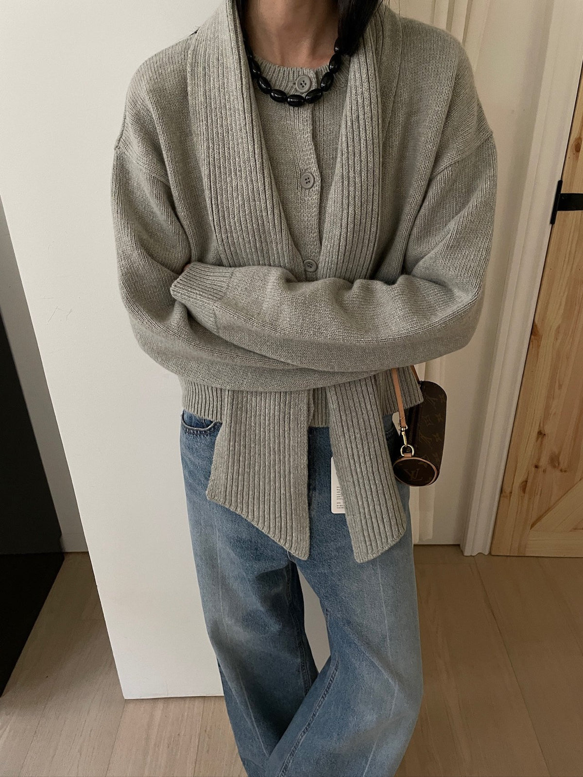 Charcoal cardigan and matching scarf worn over an ivory dress