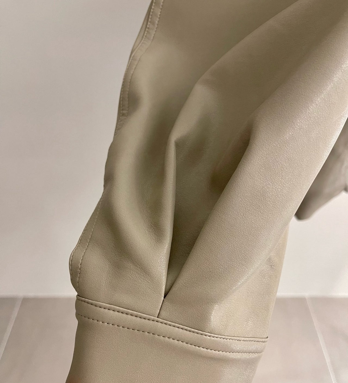 Full beige snap-front jacket displayed on a hanger