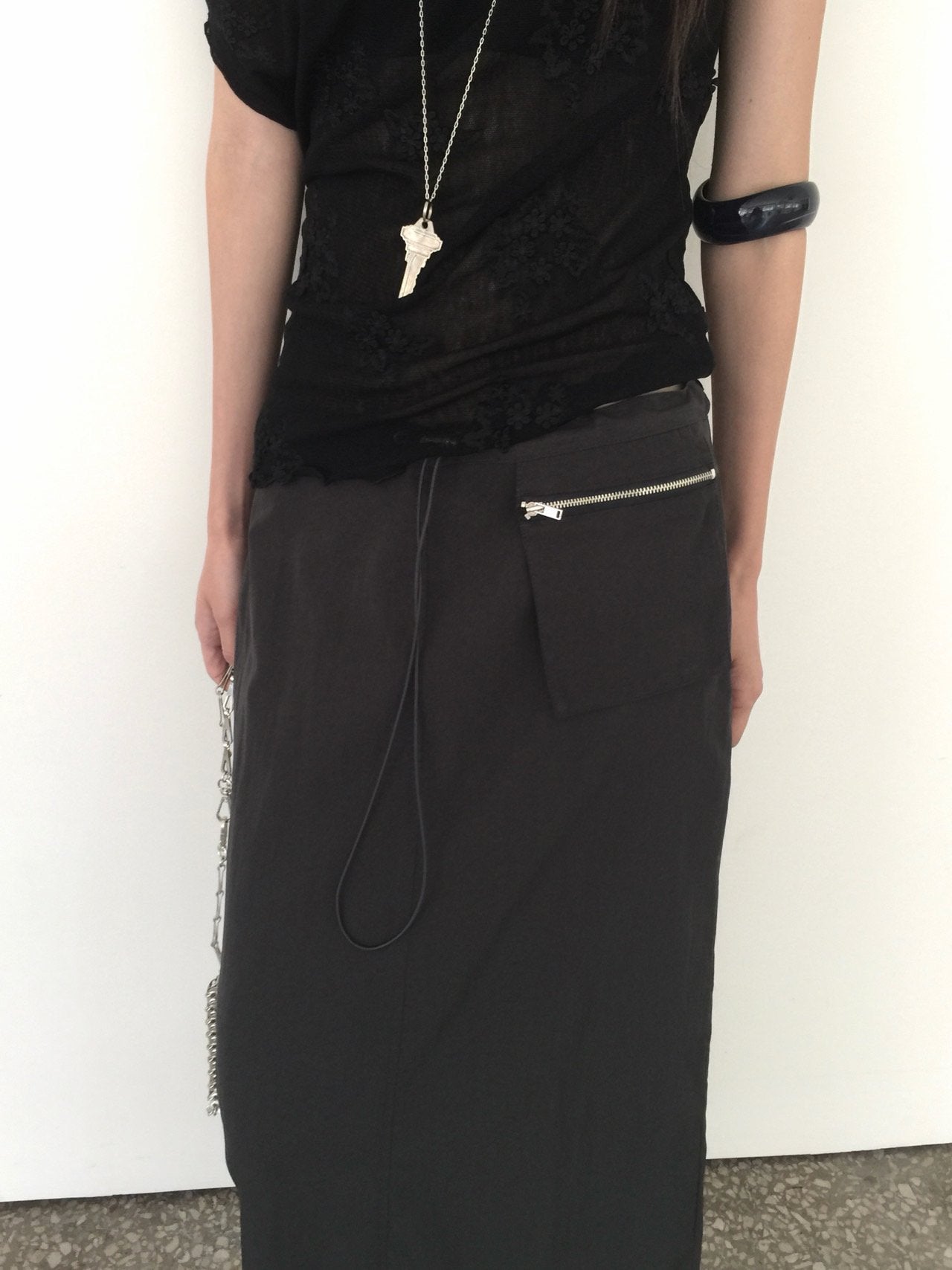 Nweol low rise zip pocket maxi skirt in Black, styled on model side view with chain bag