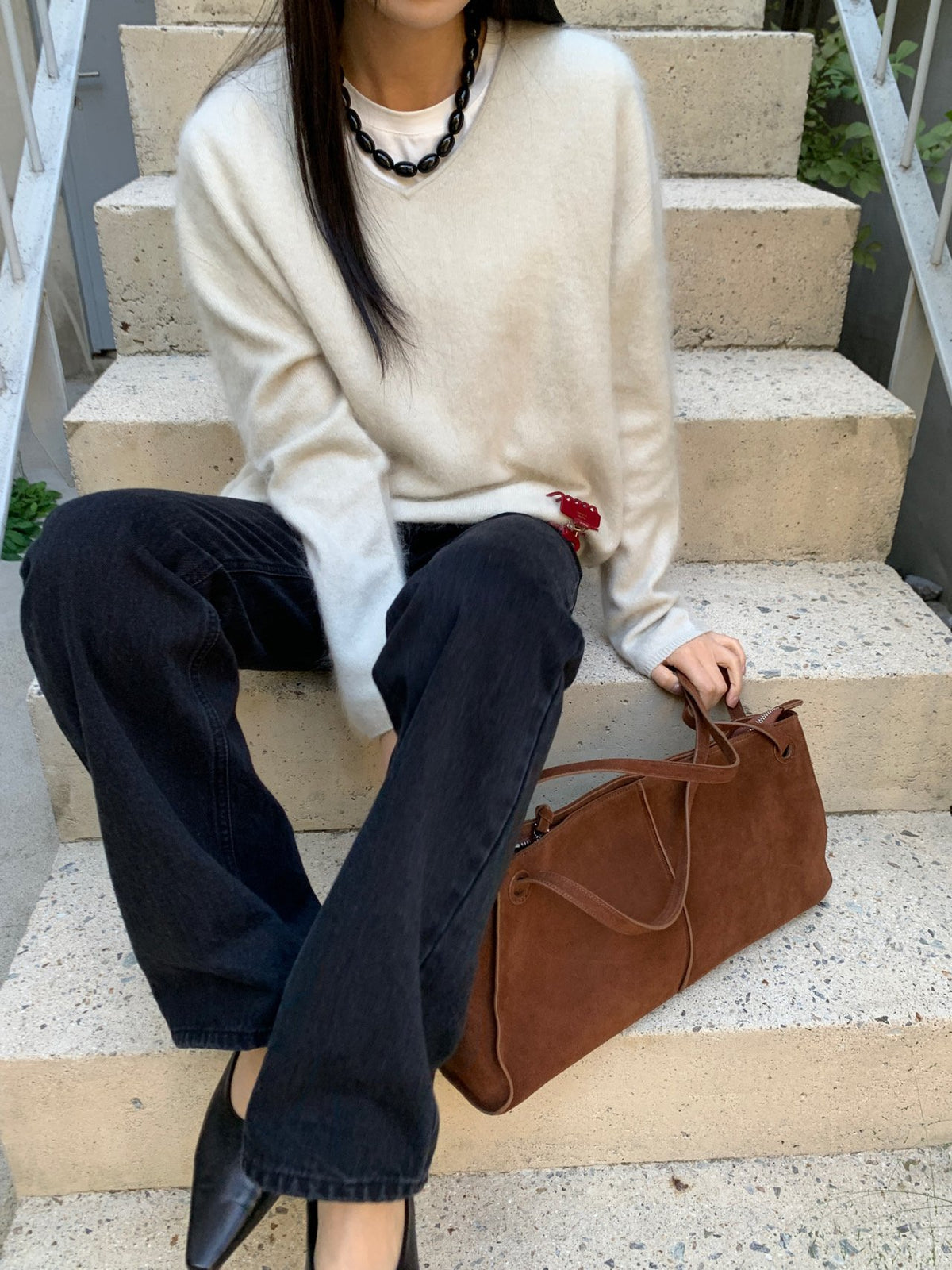 Five V-neck sweaters displayed on hangers in Ivory, Beige, Mocha, Brown and Charcoal