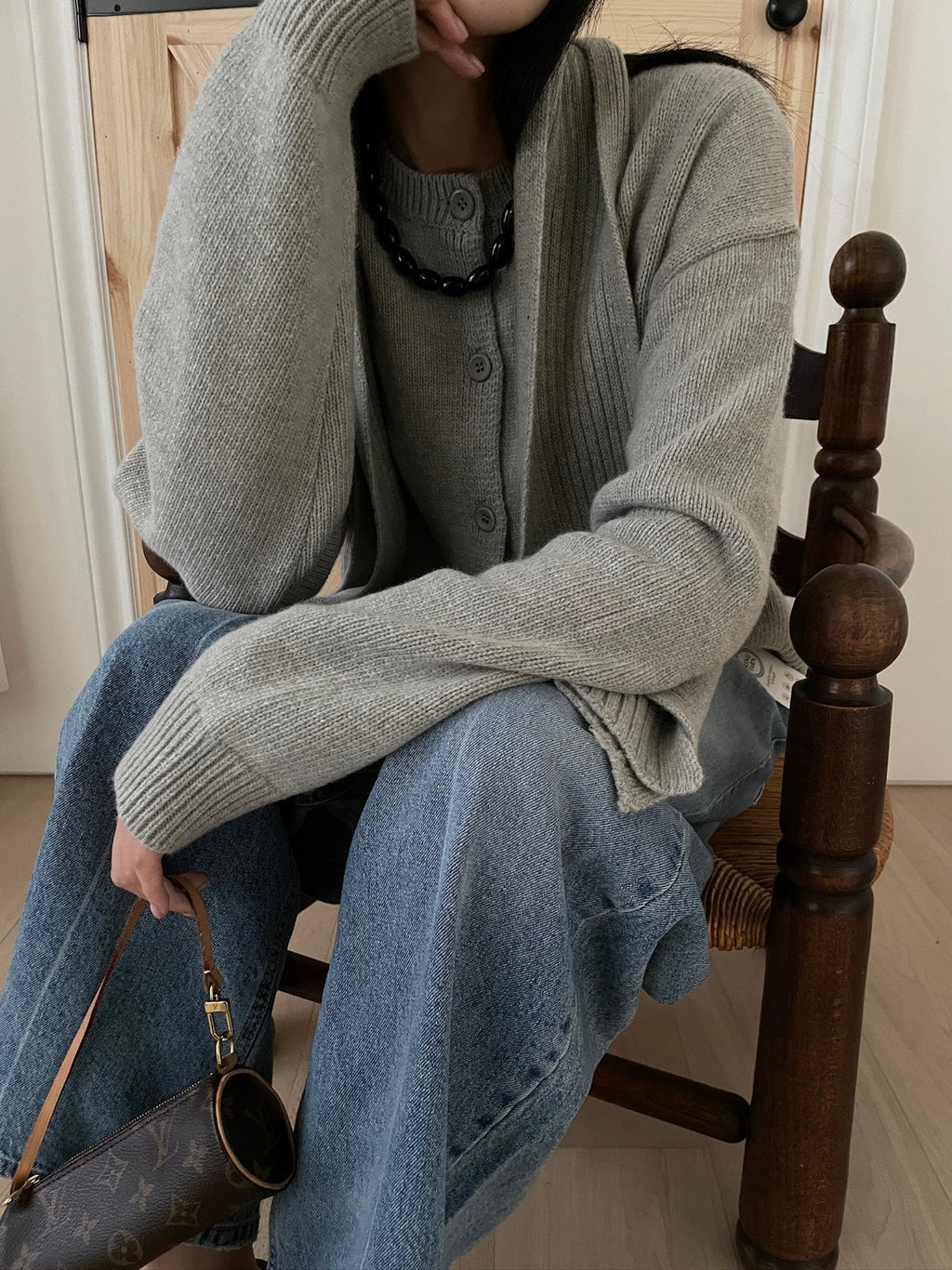 Khaki cardigan and scarf shown while seated
