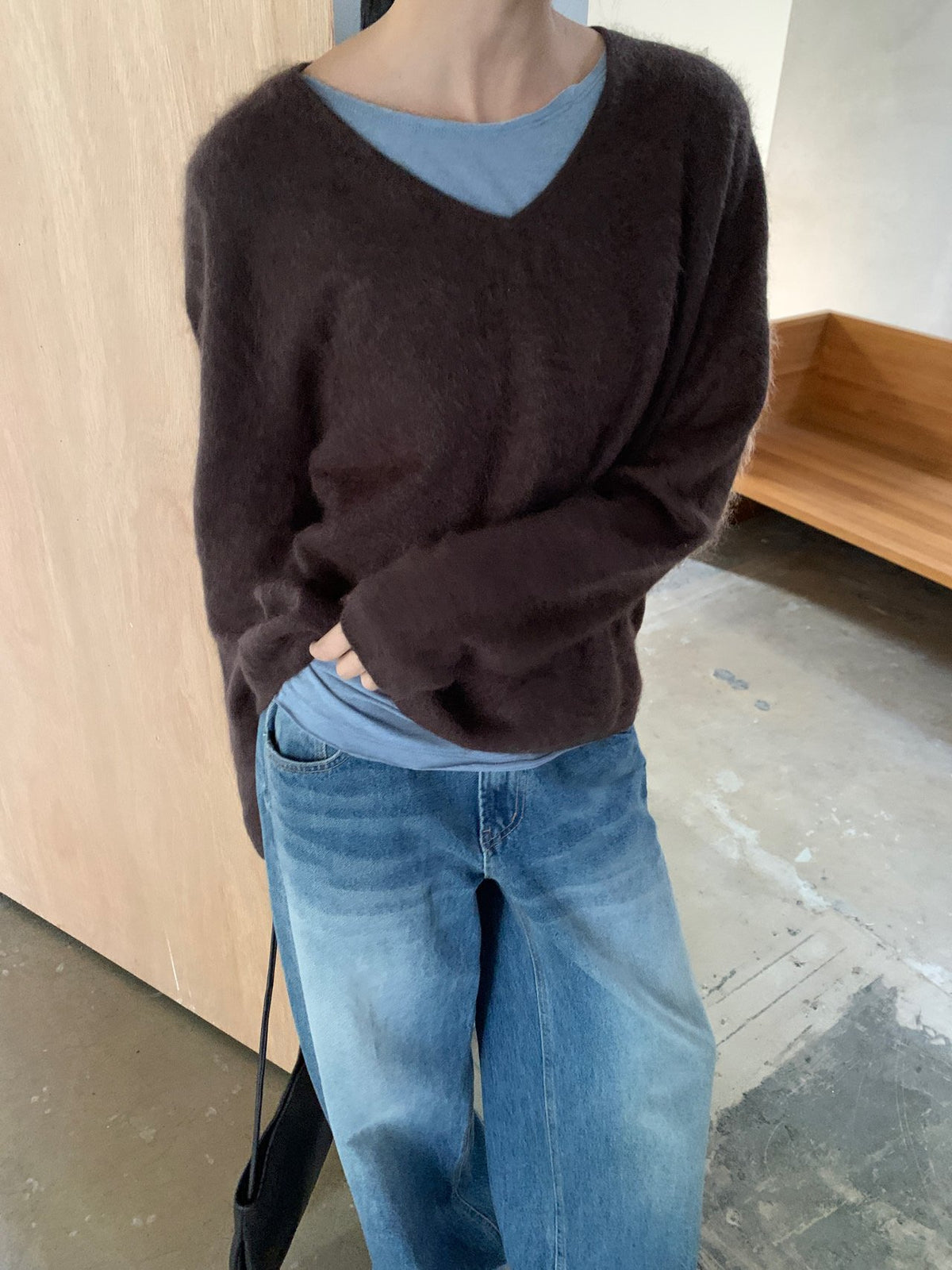 Ivory V-neck sweater with long sleeves worn with blue jeans