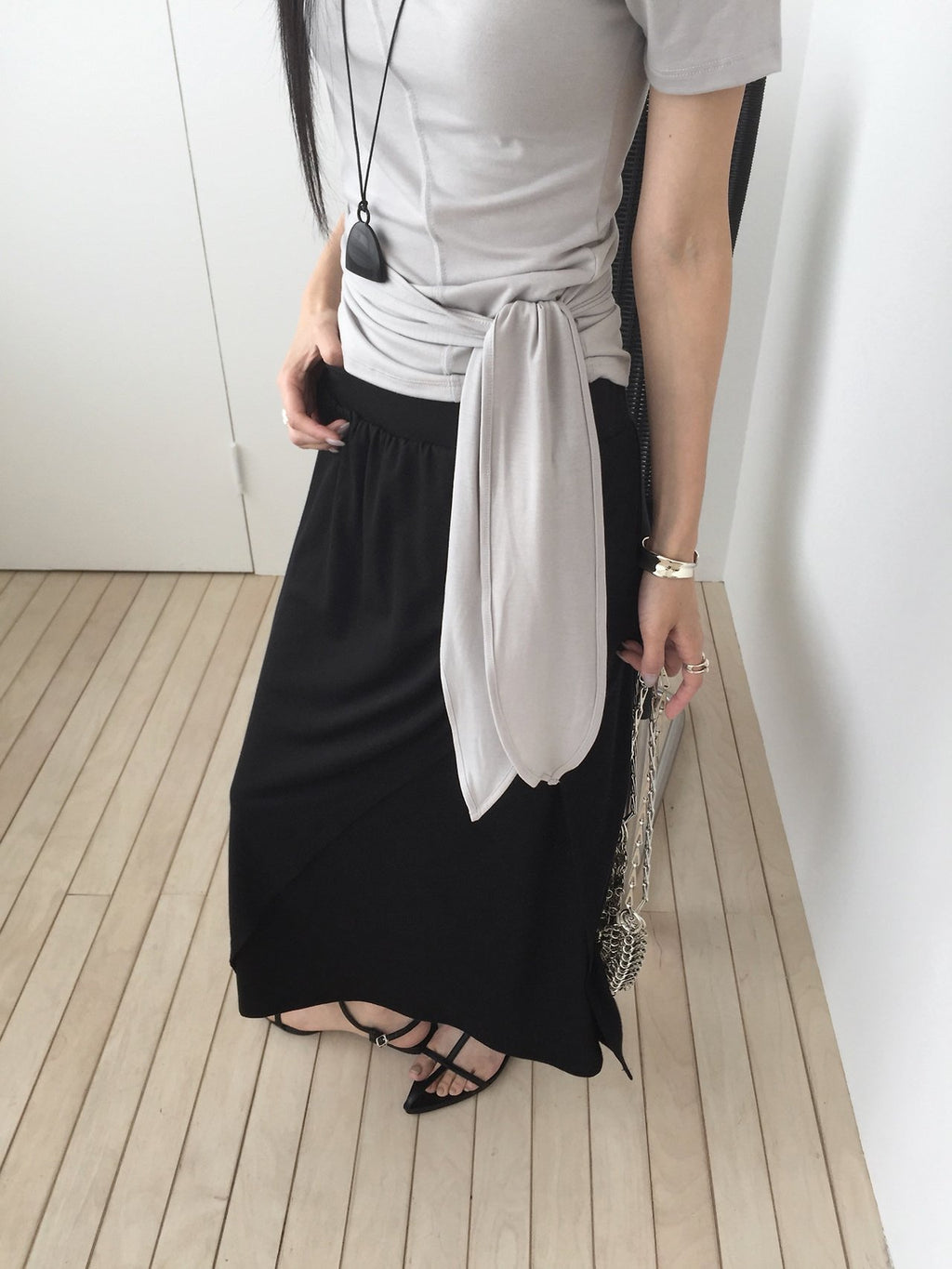 Nweol off-shoulder crop top with tie waist in Light Grey, styled on model front view with chain bag detail