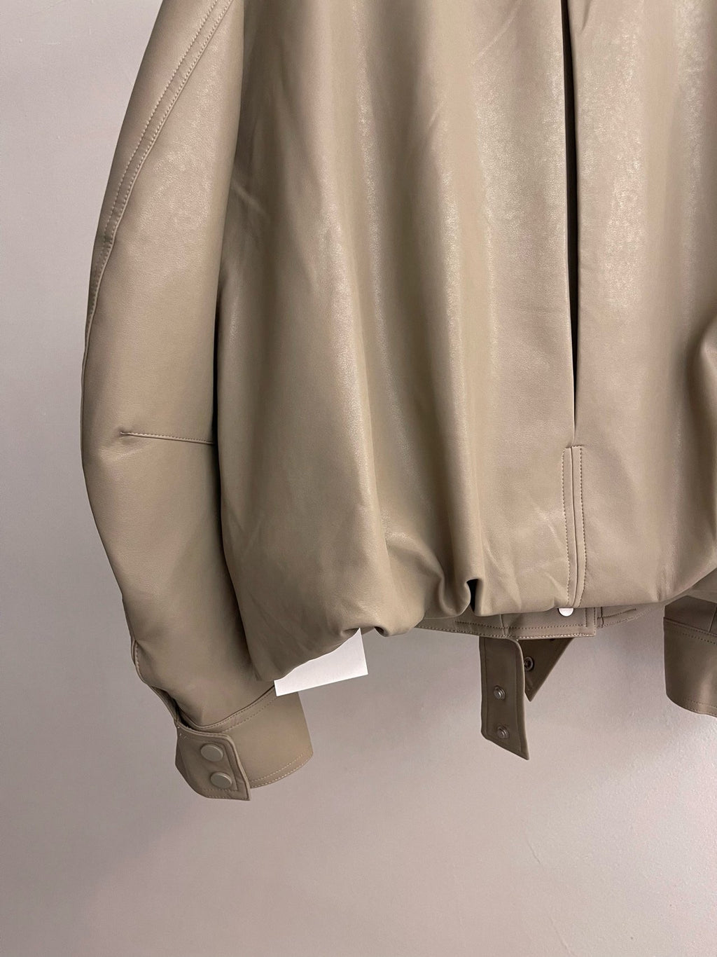 Close-up of beige jacket sleeve seam and cuff stitching