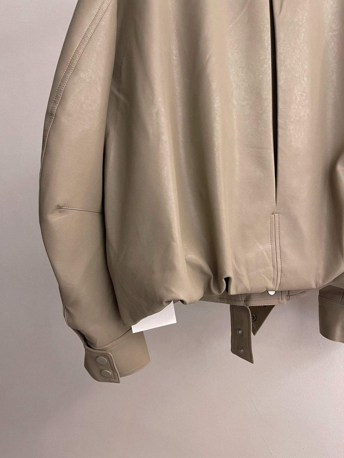 Close-up of beige jacket sleeve seam and cuff stitching