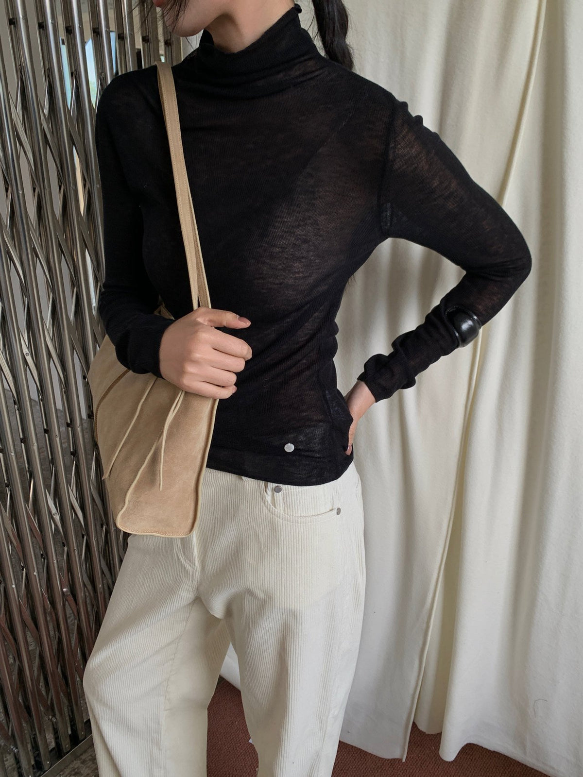 Close-up of ivory turtleneck sweater neckline and knit texture
