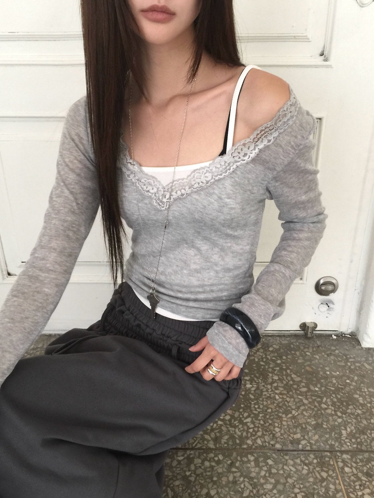 Nweol lace trim V-neck long sleeve top in Grey, styled on model front view standing by door