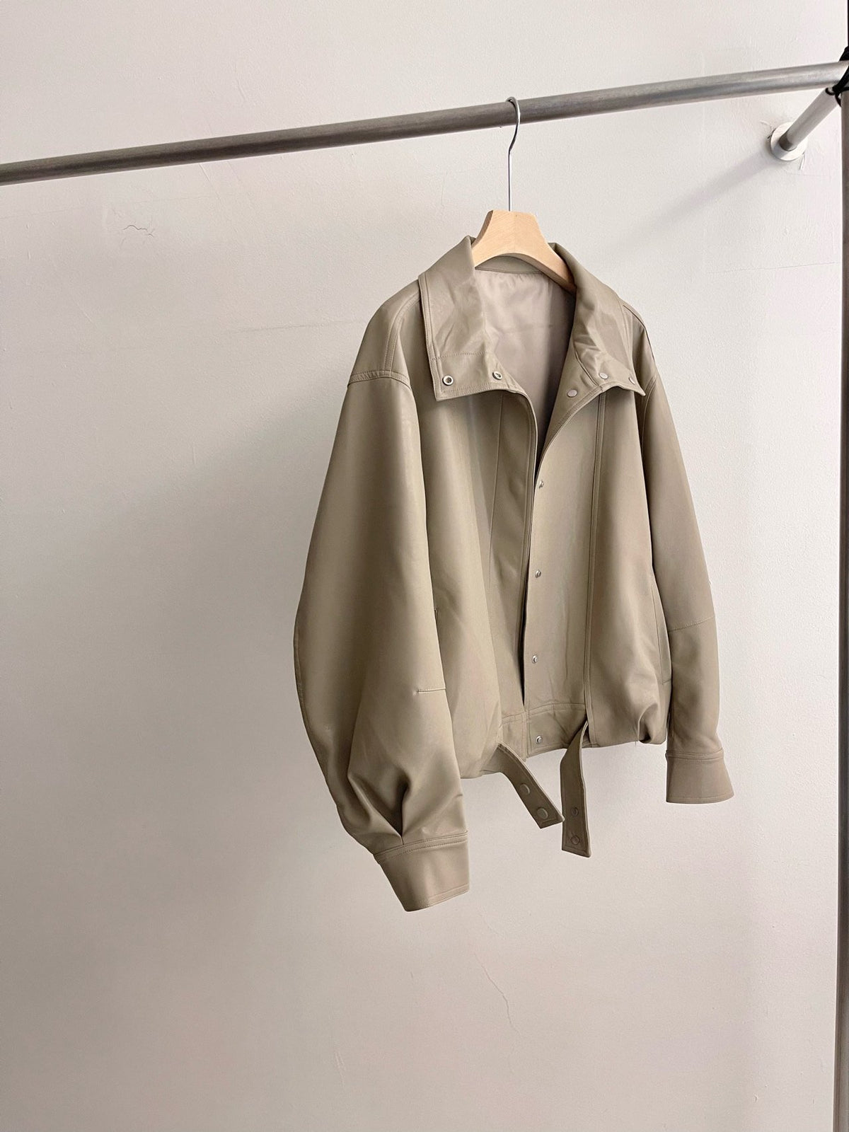 Full outfit showing beige jacket worn open with white trousers