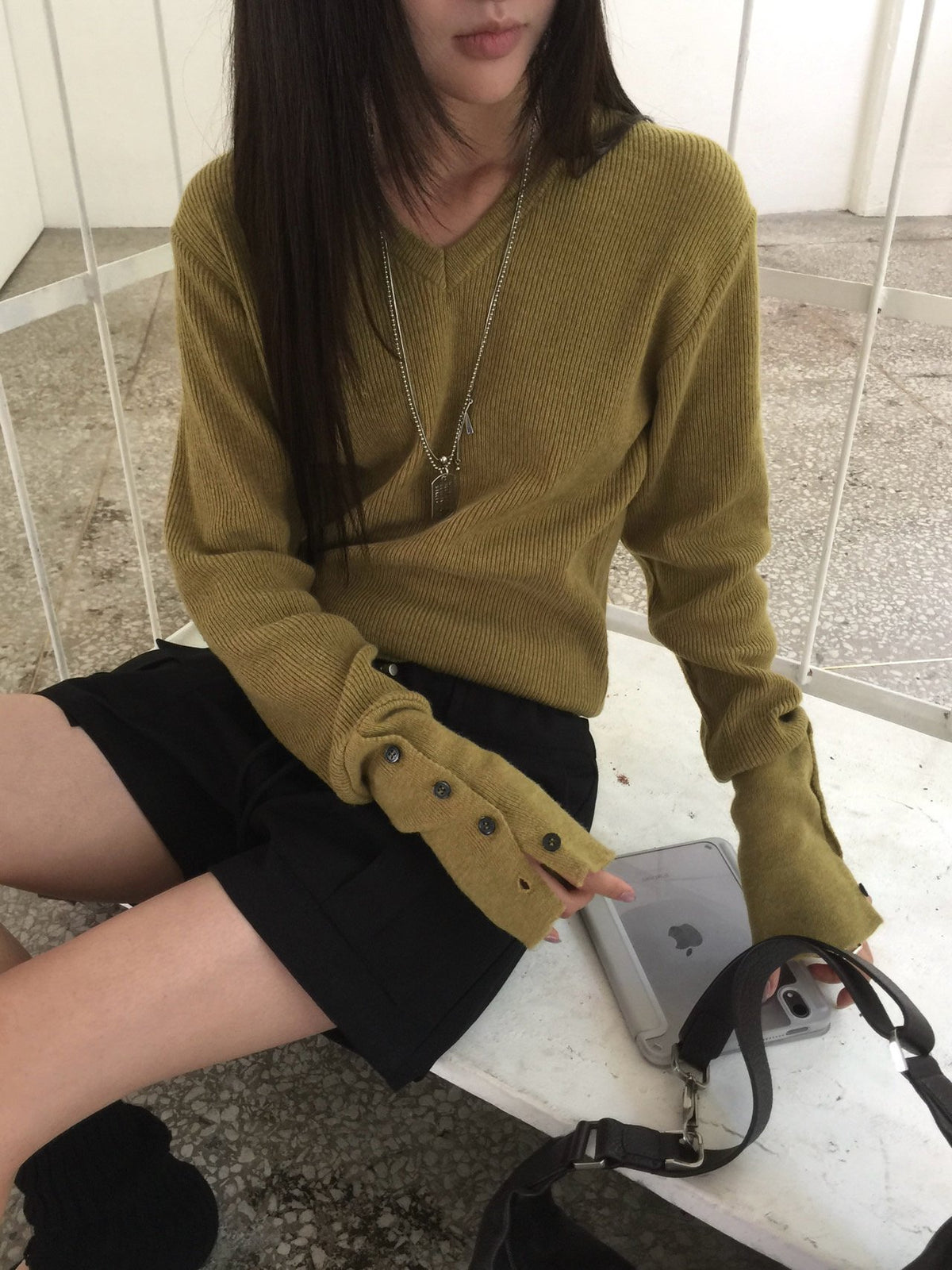 Women's olive V-neck knit sweater with long sleeves and button cuffs